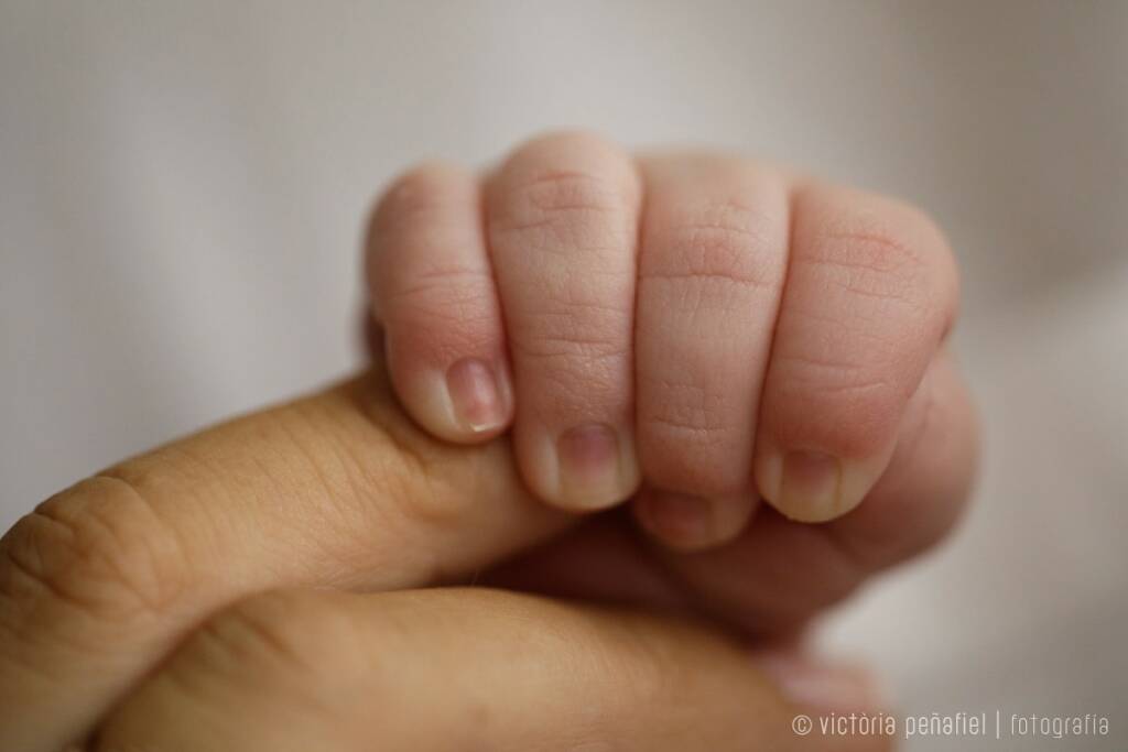 mano de un bebé agarra el dedo de su madre